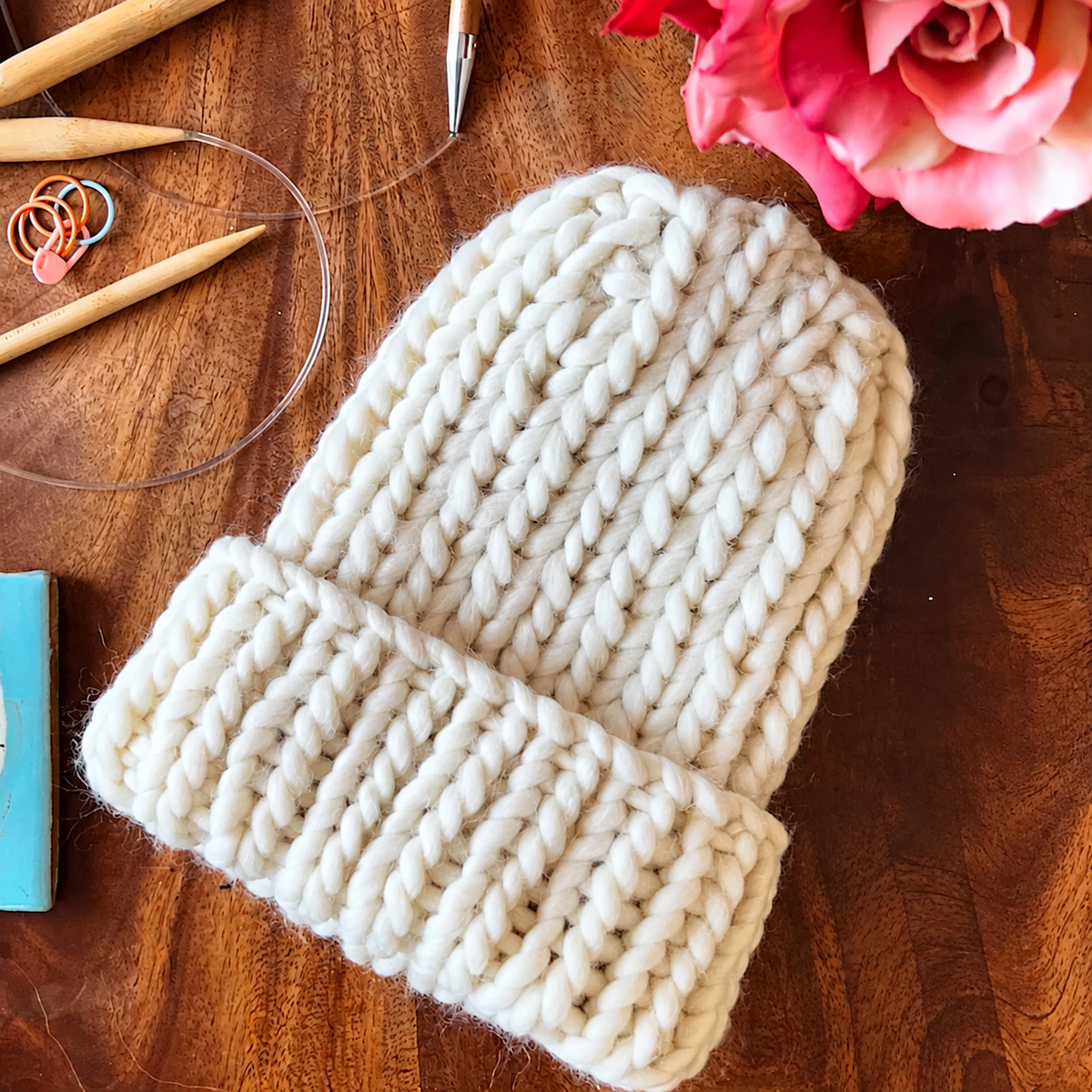 White Super Chunky Ribbed Beanie with folded cuff, shown with knitting needles