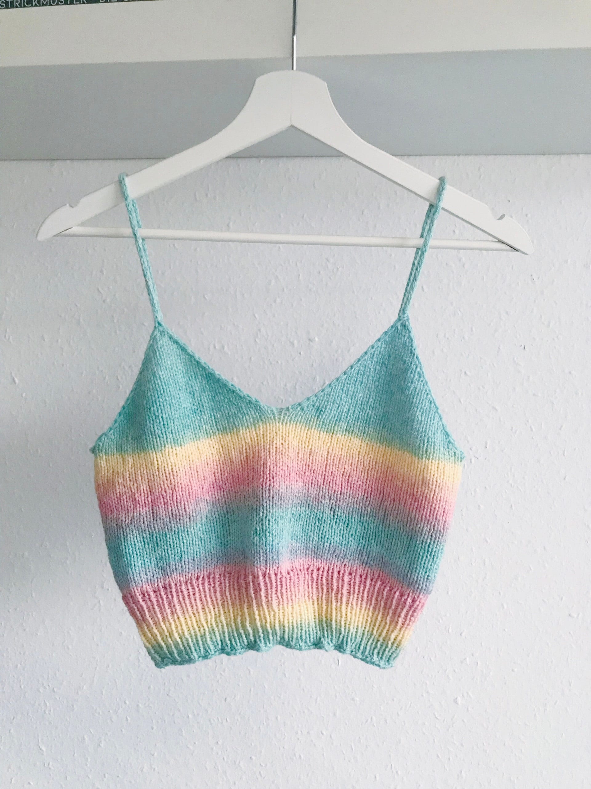 Pastel striped knitted camisole on a hanger