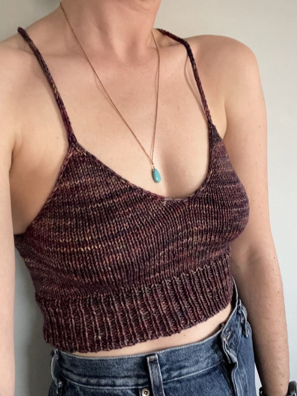 Person wearing a burgundy knitted camisole