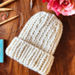 White Super Chunky Ribbed Beanie with folded cuff, shown with knitting needles