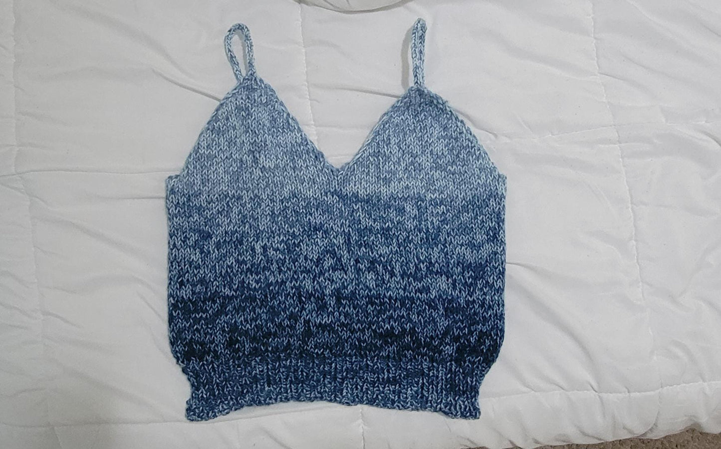 Blue knitted camisole laid flat